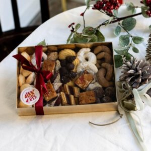 Christmas cookies in a box with a bow on a table.